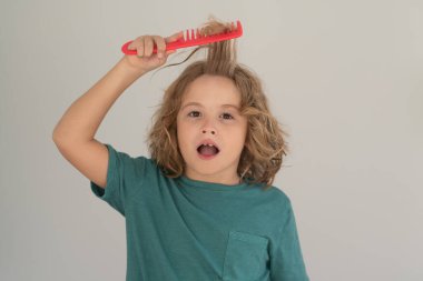 Çocuk duştan sonra saçlarını tarıyor. Saçlarını tarayan bir çocuk. Komik çocuk saç kesimi