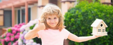 Çocuk arka bahçedeki bir oyuncak evde oynuyor. Genç aile için konut kavramı