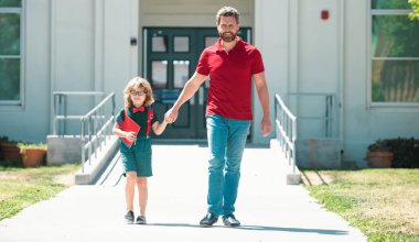 Açık hava okulu. Okullu çocuk babamla aynı okula gidiyor. Okul kapısının önünde çocuklu bir ebeveyn