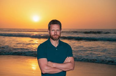 Sahildeki adam. Modaya uygun gömlek giyen muhteşem şık bir adam. Yaz gün batımı