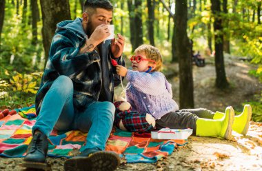 Baba ve oğul sonbahar ormanda oynuyor. Burun silecek Park sarı ağaçları arasında genç çocukla hapşırma. Baba ve çocuk evlat gülen ve having fun Sonbahar Park