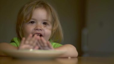 Bebek kaşıkla yiyor. Çocuk yemeğini ye. Çocuk maması yiyen aç küçük bir çocuk. Bebek yulaf lapası. Küçük bebek sağlıklı yemek yiyor. Küçük bir bebek yemeğini yiyor. Çocukların yüz ifadesi