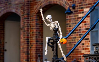 Cadılar Bayramı iskelet süslemeleri. Dekorasyon için cadılar bayramı iskeleti. Bir Amerikan evinin ön bahçesinde dekore edilmiş korkunç bir iskelet. Şeker mi şaka mı? Cadılar Bayramı iskelet arka planı