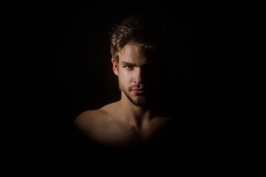Moda erkek modeli. Üstsüz vücutlu yakışıklı bir adam. Kas modeli. Güçlü, vahşi adam. Yakışıklı spor modelinin portresi. Stüdyoda çıplak vücut pozu veren yakışıklı bir genç. Seksi erkek model.