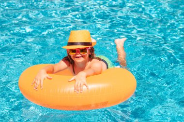 Çocuk havuzda su sıçratıyor, eğleniyor, boş vakit geçiriyor. Yüzme havuzunda bir çocuk. Yaz yaşam tarzı. Yaz tatilinde çocuklarla yüzme sporu aktivitesi