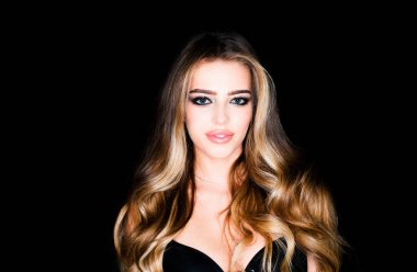 Kozmetik güzellik ve kaplıca. Güzellik ve güzellik merkezi. Moda butiği reklamı. Yüksek moda. Sarışın, kıvırcık saçlı, siyah arka planda gülümseyen bir kadın.