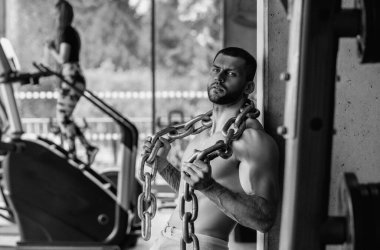 Muscular man lifting weights at gym. Handsome guy prepare to do exercises with dumbbell