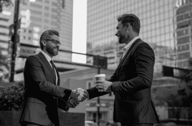 Amerikalı işadamı ortağıyla tokalaşıyor. Takım elbiseli işadamları dışarıda el sıkışıyor. İki işadamı arasında tokalaşma. İki iş adamının iş bağlantıları vardı. İş stratejisi
