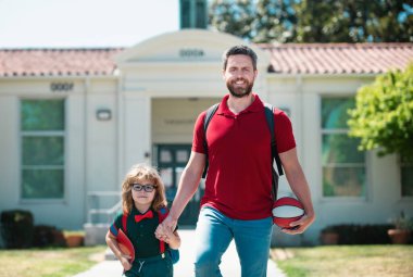 Amerikan baba ve oğlu okul parkında yürüyor. Ebeveyn çocuğu okula götürür. İlkokul öğrencisi dışarıda sırt çantasıyla ders çalışmaya gitti. Baba ve çocuk el ele gidiyor. Dersler başlıyor.