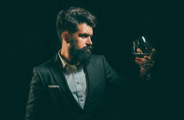 Sakallı adam cam brendi tutar. Degustation ve tatma. Viski yudumlarken