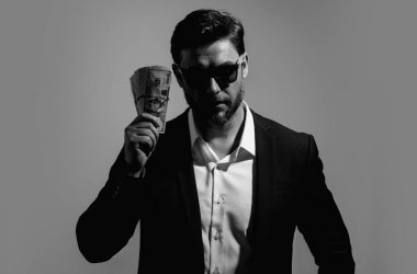 Dolar banknotları olan bir adam. Bir sürü 100 dolarlık banknot tutan bir iş adamı. Kolay para. Kara para. Ödeme günü ve ödeme konsepti. Kâr ve zenginlik. Para kazan. İş adamı başarılı anlaşma