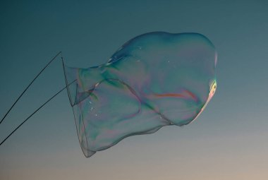 Dev renkli baloncuk. Mavi gökyüzünde büyük bir sabun köpüğü. Büyük ip sabun köpükleri yapıyorum.