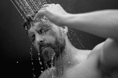Adam banyoda saç yıkıyor. Küvette banyo yapan adam. Duşta erkek yüzü. Adam banyoda duş alıyor. Adam duş alıyor. Tuvalet konsepti. Adam banyoda su altında.