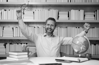 Kütüphanede kitabı olan bir öğretmenin portresi. Üniversite kütüphanesinde yakışıklı bir öğretmen. Öğretmenler Günü. Öğretmen ders veriyor. Kütüphanede öğretmen. Kitaplıktaki üniversite kütüphanesinde özel öğretmen.