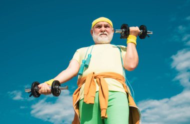 Kıdemli sportmen halter kaldırıyor. Yaşlı adam egzersiz