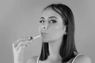 Rujla poz veren üstsüz bir kadının fotoğrafı, izole bir stüdyo geçmişi var. Omzunda ruj izi olan güzel bir kadın. Ruj kullanan seksi kız.