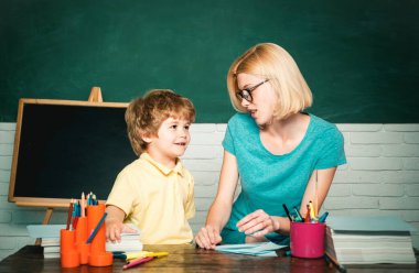 İlkokul - eğitim ve öğrenme çocuk konsepti. Öğretmenler okulda çocukların ödevlerine yardım ediyor. Öğretmenler Günü