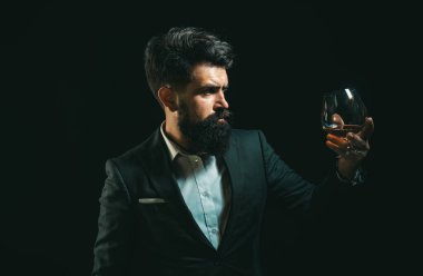 Viski, konyak ya da konyak içmek. Klasik klasiklerde zarif ve şık bir adam elinde bilge bir bardakla gezer. Bir bardak viski tutan şık zengin adam.