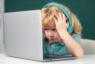 Bilgisayar sınıfında çalışan kızgın üzgün bir okul çocuğu. Küçük komik sistem yöneticisi veya programcısı