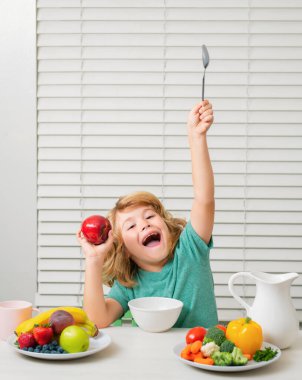 Heyecanlı şaşkın çocuk organik yiyecekler yiyor. Vitaminli sağlıklı sebzeler. Gerçek çocuk beslenme konsepti