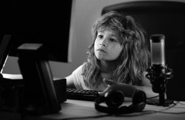 Zeki çocuklar çevrimiçi evde öğreniyor. Beyaz çocuk geceleri karanlık odada dizüstü bilgisayarla çalışıyor. Okul, eğitim, çevrimiçi öğrenme kavramı