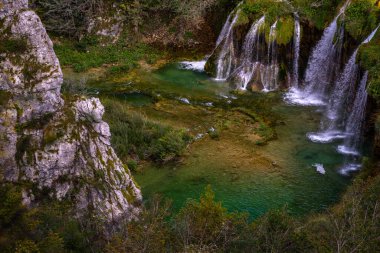 Plitvice Lakes Ulusal Parkı. Hırvatistan. Büyük şelaleler. Doğa yolculuğu geçmişi. Güzel doğa. Hırvatistan 'daki Plitvice şelaleleri. Dağ dereleri masmavi berrak suyla bir göle akar.