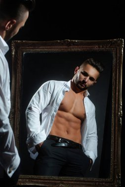 Yakışıklı kaslı adam. Formda seksi erkek modelin seksi vücudu. Mükemmel kaslı vücudu olan bir güzellik adamı. Seksi çıplak, genç, orta doğulu adam kaslı vücudunun tadını çıkarıyor. Gömleksiz, portresiz ve seksi bir adam.