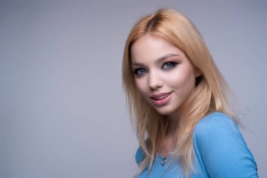 Gülen surat. Kadın yüzü mutlu bir gülümseme. Gülümseyen genç kızın yakın portresi. Dişleriyle gülümseyen, mutlu bir yüz ifadesiyle kameraya bakan genç bir kadın. Gülümseme. Gülen surat.