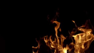 Ateş alevi dokusu. Ateş, yanan alev. Büyük, yanan bir ateş. Alevler arka planı kaplıyor. Fırın şöminesi. Şömine için kömür odunu ısıt. Alev alır. Siyah bir ışıkta ateş yak
