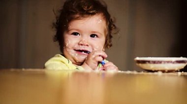 Bebek kaşıkla yiyor. Çocuk yemeğini ye. Çocuk maması yiyen küçük bir çocuk. Bebek yulaf lapası. Küçük bebek sağlıklı yemek yiyor. Şirin, eğlenceli bir bebek yemeğini yiyor. Çocukların yüz ifadesi