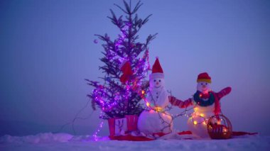 Mutlu Noeller ve mutlu yıllar. Gece kışında kardan adam. Karlı bir kış gecesinde kardan adam. Işıklı Kardan Adam Noel 'i. Geceleri kardan adam figürleri. Evin yakınındaki Noel süsleri.