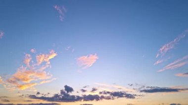 Gökyüzü zaman atlaması. Gün batımında hareket eden bulutlar. Bulutlar akşam boyunca yüzer. Alacakaranlık gökyüzü zaman aşımına uğradı. Dramatik gökyüzü hareket ediyor. Kümülüs ve sirrus fırtınada. Gün doğumu bulutu