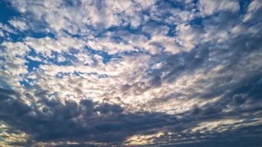 Gün batımında güneş, bulutlarda mavi ve turuncu dramatik gökyüzünde güneş ışınları. Gece Gökyüzü zaman çizelgesi. Gün batımında hareket eden bulutlar. Akşam bulutları. Alacakaranlık gökyüzü zaman aşımına uğradı. Dramatik gökyüzü