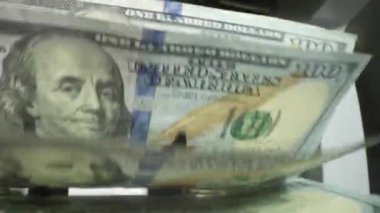 Para saymak. Para sayma makinesini kapat ve dolarları say. Makine sayacı 100 dolarlık banknotları yavaş çekimde hesaplar. Kapatma para sayma makinesi dolar banknotlarını sayıyor