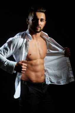 Yakışıklı kaslı adam. Formda seksi erkek modelin seksi vücudu. Mükemmel kaslı vücudu olan bir güzellik adamı. Seksi çıplak, genç, orta doğulu adam kaslı vücudunun tadını çıkarıyor. Gömleksiz, portresiz ve seksi bir adam.