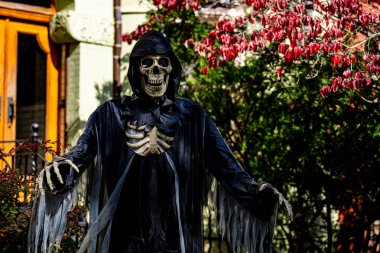 Cadılar Bayramı süslemeleri. Cadılar Bayramı balkabağı ve dekore edilmiş ev için iskelet. Bir Amerikan evinin ön bahçesinde dekore edilmiş korkunç bir şey. Şeker mi şaka mı? Cadılar Bayramı geçmişi. Cadılar Bayramı 'nın sonbahar tatili