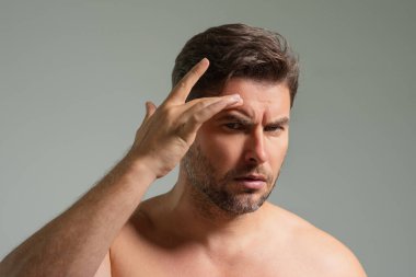 Milenyum İspanyol erkeği tenine, cildine ve sakalına dokunur. Erkek güzellik ürünleri. Cilt bakımı, spa. Güzel bir adamın güzel portresi. Spa modeli, nemlendirici cilt kremi