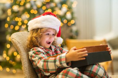 Noel Baba şapkalı mutlu çocuk elinde Noel hediyesi tutuyor. Noel ve Yeni Yıl kavramı