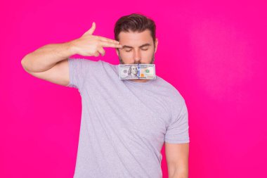 Yakışıklı orta yaşlı adam pembe stüdyoda izole edilmiş para tutuyor. Dolar banknotları halinde para. Yığınla para, finans, yatırım ve tasarruf. Model pankart, ödeme konsepti