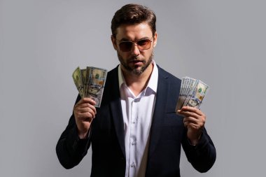 Dolar banknotları olan bir adam. Bir sürü 100 dolarlık banknot tutan bir iş adamı. Kolay para. Kara para. Ödeme günü ve ödeme konsepti. Kâr ve zenginlik. Para kazan. İş adamı başarılı anlaşma
