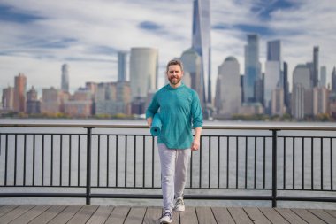 Spor salonundaki adam Manhattan yakınlarında egzersiz yapıyor. Sağlıklı egzersizler. Aktif kıdemli adam dışarıda fitness egzersizi yapıyor. Emeklilikten sonra egzersiz. Olgun emekli sporcu esneme egzersizleri yapıyor.