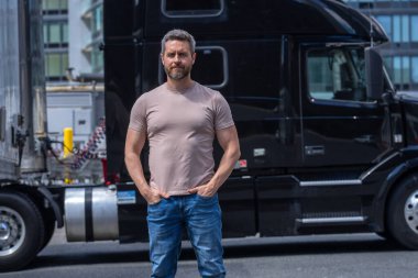 Kamyon şoförü. CDL. Kamyon aracının yanında nakledilmeye hazır duran kamyoncu portresi. Kamyonun önünde duran bir erkek sürücü.