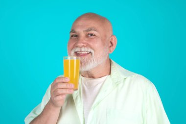 Sunbae stüdyoda portakal suyu içiyor. Yaşlı adam elinde bir bardak portakal suyu tutuyor. Portakal suyu olan adam. Yaşlılar için meyve. Son sınıf diyeti, sağlıklı yaşam tarzı. Stüdyo portresi ve portakal suyu.