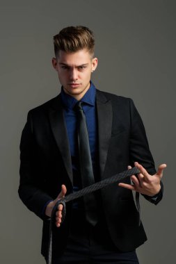 Adam kravat bağlıyor. Resmi erkek giyimi. Smokin ya da resmi takım elbise için Boyunbağı. Kravatlar ve fiyonklar. İş adamı kostümü. Kravatlı bir erkek model. Klas takım elbiseli genç adam kravat ayarlıyor. Moda görünüşü.