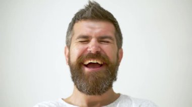 Adam yüz ifadelerine gülüyor. Erkek Karakteri, Gülme, Şok Olmuş Duygular İfadesi. Yüzünde gülme ifadesi olan sakallı bir adamın yakın plan portresi. Gülmek heyecan verici Duygu