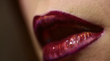 Güzellik ruju. Kırmızı dudaklı makro makyaj. Dudaklarına ruj süren genç ve güzel bir kadın. Dudak parlatıcısı yakın plan. Kadın dudakları için kozmetik. Rujla sürüyorum. Kırmızı ruj süren genç bir kadın.
