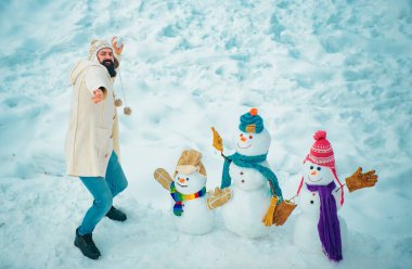 Genç hipster kış portresi. Noel hazırlığı. Komik sakallı adam kardan adam yapar. Kardaki insanlar. Kardan adam. Komik kış insanları Portresi