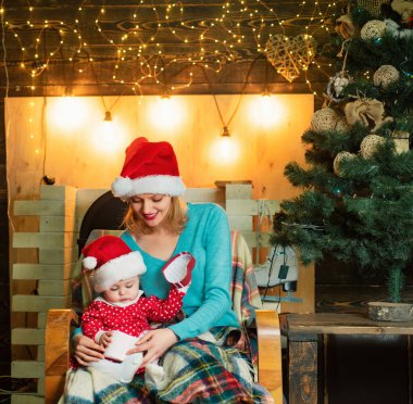 Mutlu Noeller ve mutlu yeni yıl. Anne ve kızı Noel ağacı süsleyin. Noel sevgi dolu aile