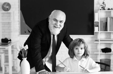 Profesör ya da öğretmen küçük öğrenciyi eğitiyor. Öğretmen yetenekli bir lider. Eğitici konuşma. Öğrencilerle ya da öğrencilerle konuşmak. Öğretmen konsepti. Pedagog ve öğrenci eğleniyor.