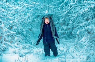Mutlu Noeller ve mutlu Noeller. Kış çocuğu. Kar tarlasında küçük bir çocuk. Doğanın tadını çıkarıyorum. Kış kavramı Çocuklar ve doğa
